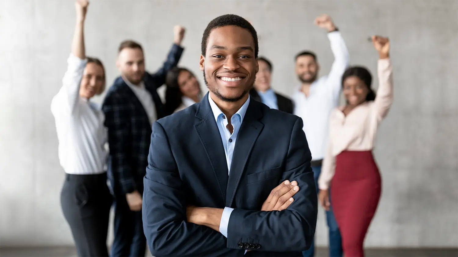 Image of a strategy consultant smiling in front of happy employees.