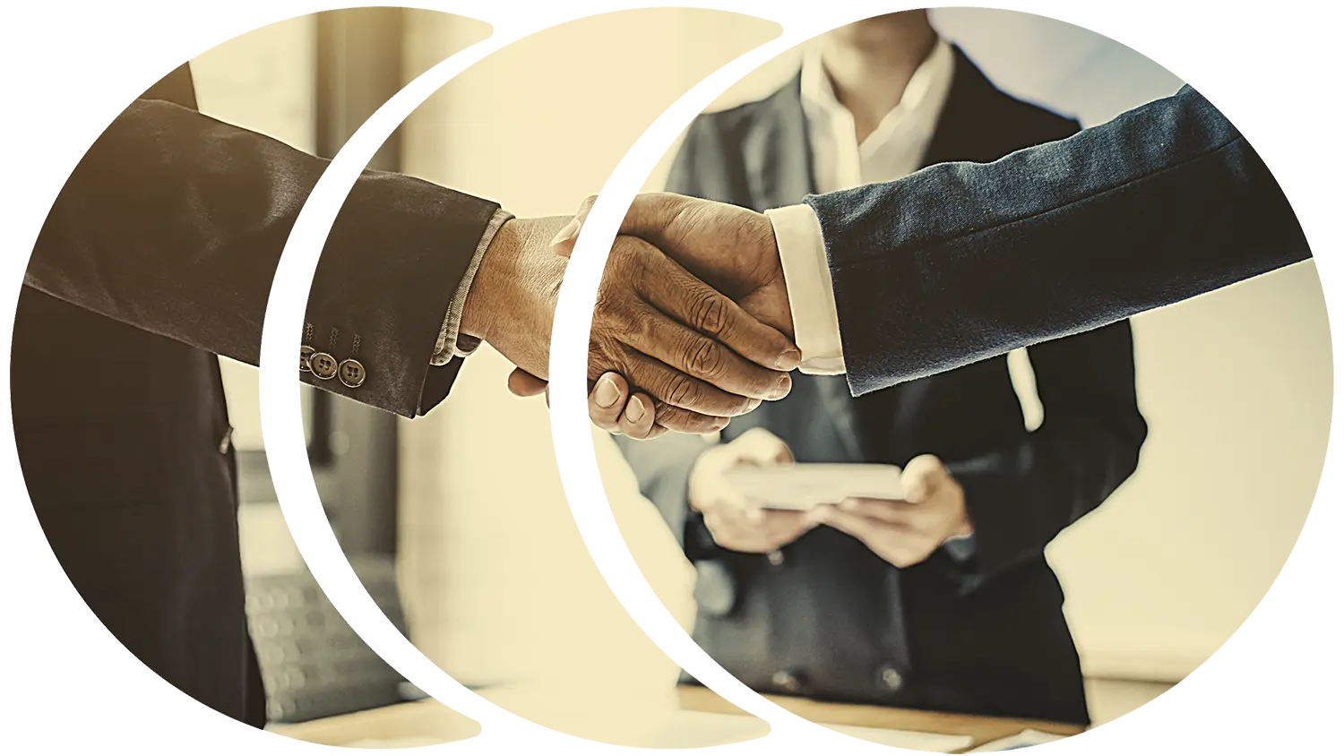 Image of two businessmen shaking hands with a business woman in the background.