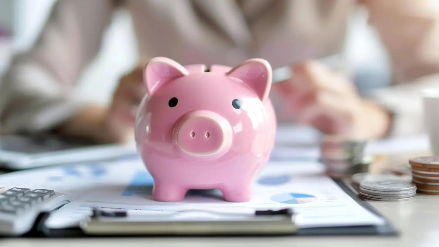 Image of a piggy bank in front of a business woman calculating the cost of hiring a consultant.